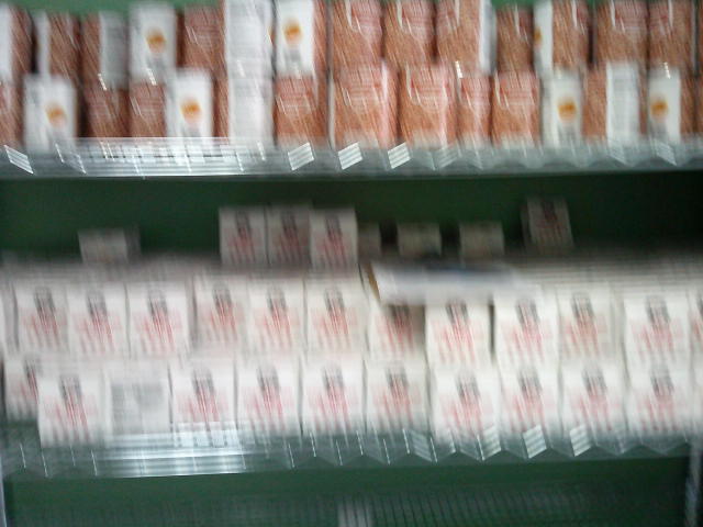 Canned pinto beans on the top shelf and boxes of rice and red beans on the middle shelf.